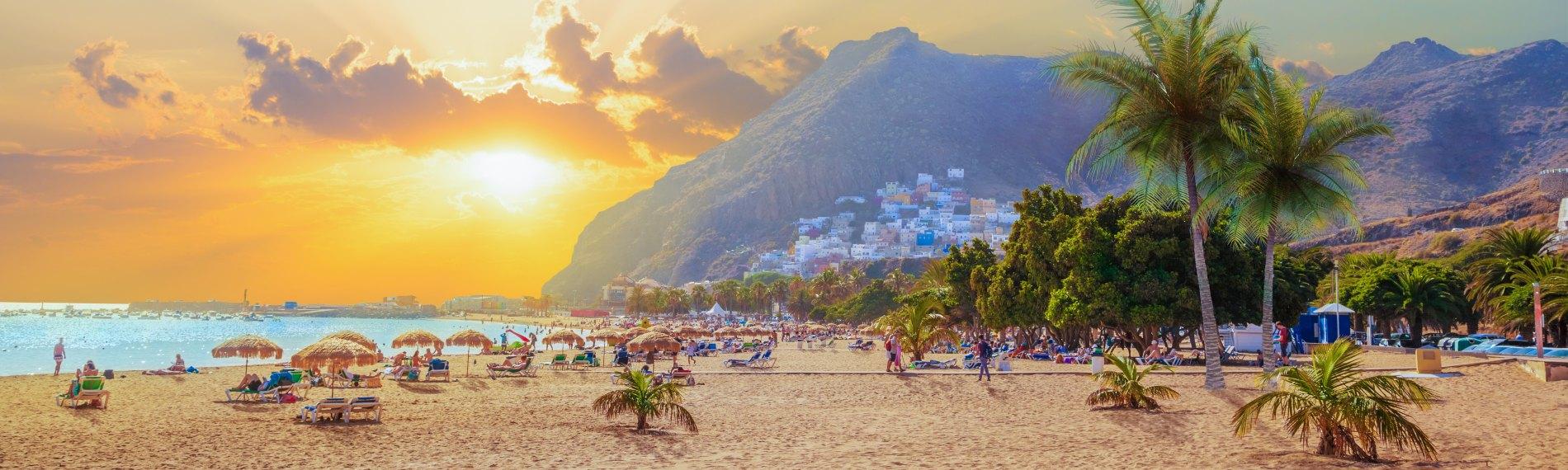 Sunset over the white sands of Playa de las Teresitas beach in Tenerife, with San Andres village in the background